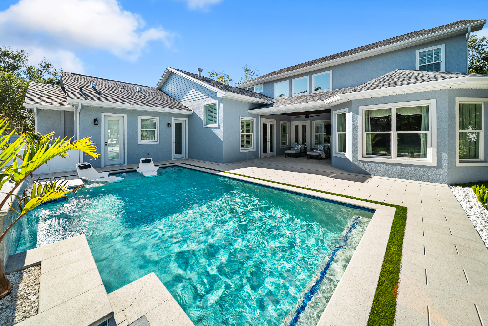 Large geometric pool with 2 loungers and a watefall