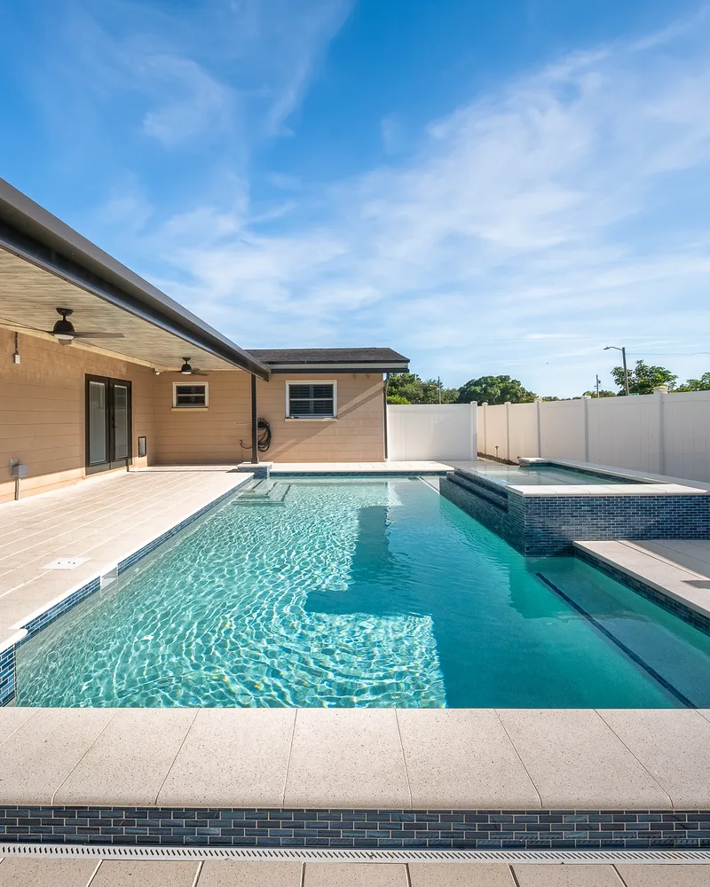 Ivory Shellock shell stone coping running along the edge of a custom pool