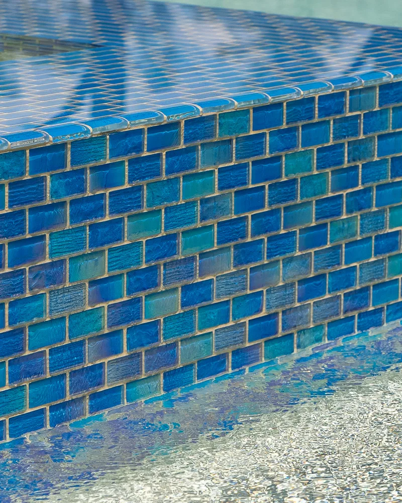 Custom pool and raised spa with Blue Lagoon glass tile built by Pool Perfection in Wesley Chapel
