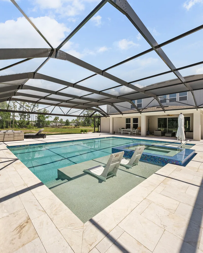 Royal Beige sandblasted marble pool deck under a screen enclosure