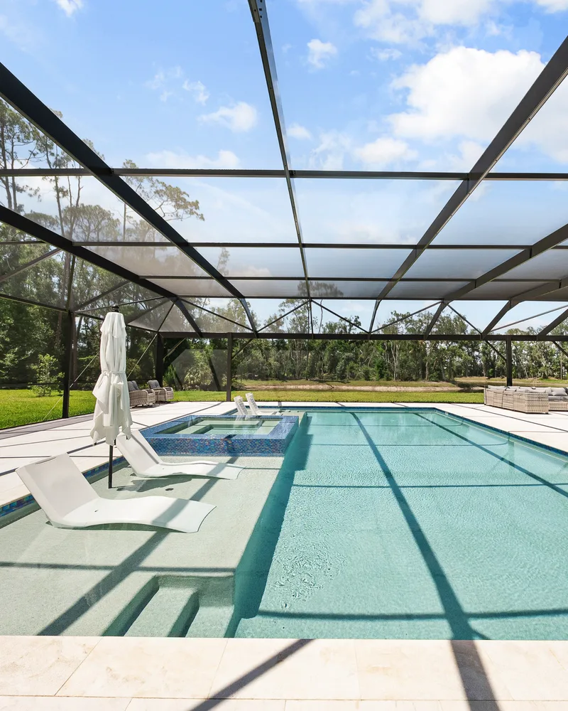 Custom pool and raised spa with Blue Lagoon glass tile built by Pool Perfection in Wesley Chapel